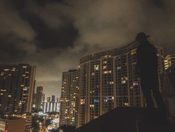 Low angle view of illuminated buildings against sky at night