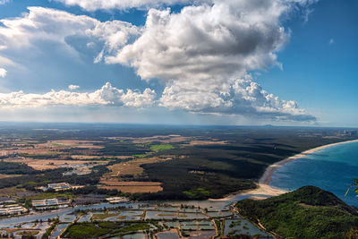 Aerial view of city by sea against sky