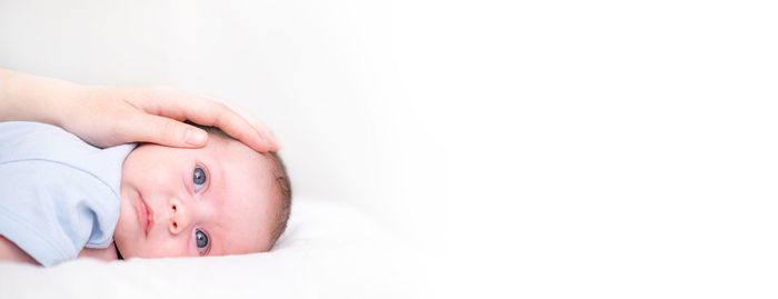 Low section of baby boy against white background