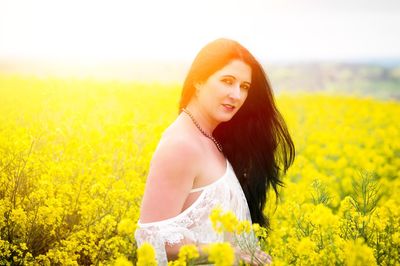 Portrait of beautiful woman standing on field