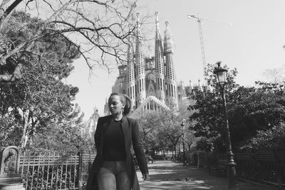 Woman walking on pathway against sagrada familia