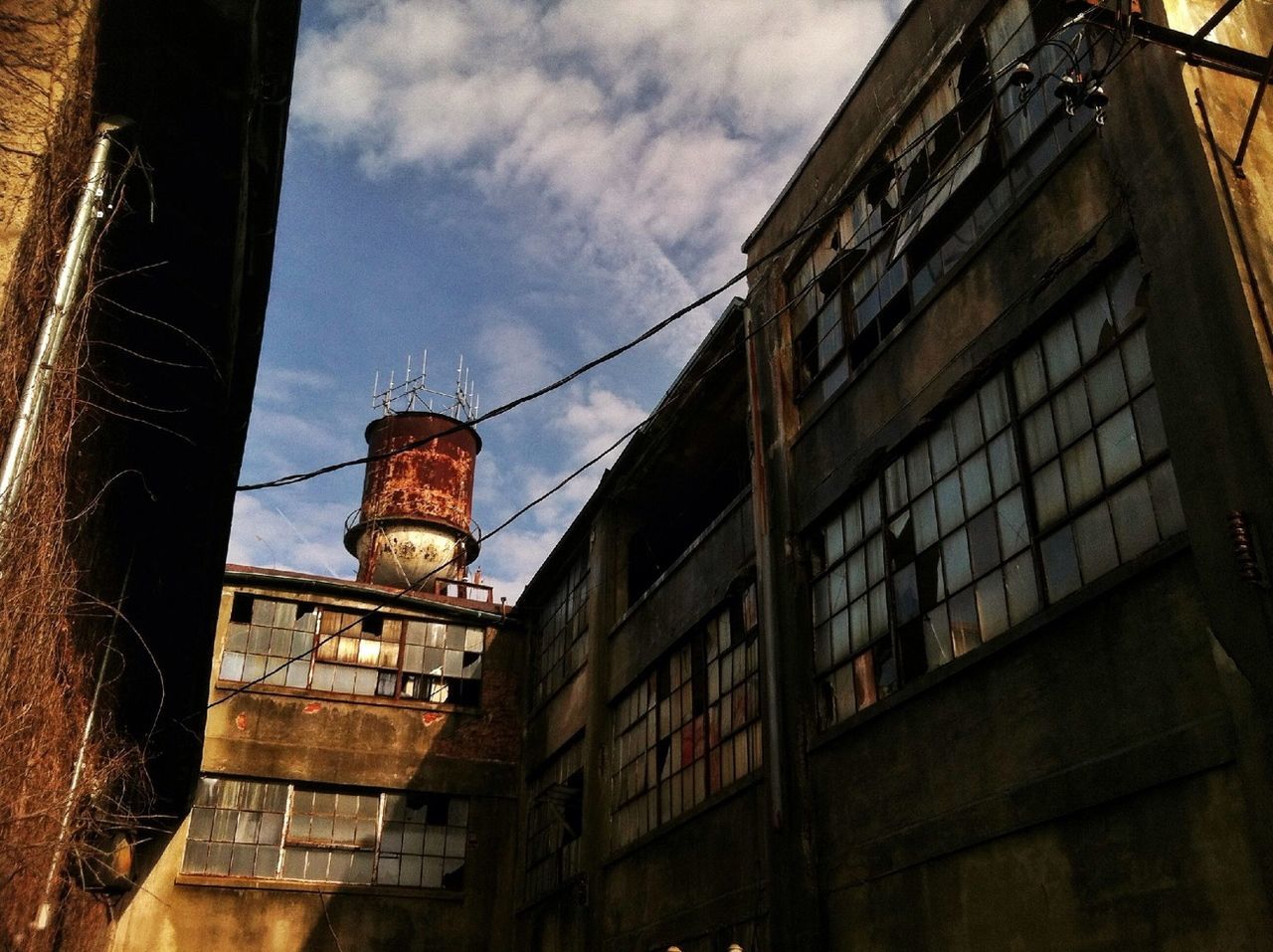 architecture, building exterior, built structure, low angle view, sky, building, window, cloud - sky, residential building, city, tower, cloud, residential structure, outdoors, no people, day, street light, cloudy, high section, brick wall