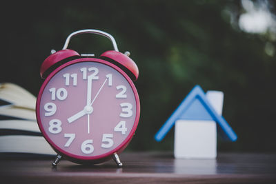 Close-up of open books and clock on table