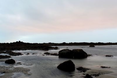 Rocks in sea against sky