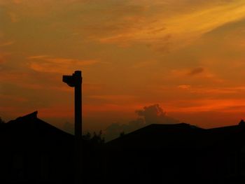 Silhouette building against dramatic sky during sunset