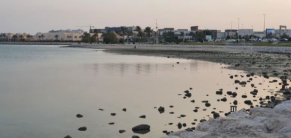 Scenic view of sea and buildings against clear sky