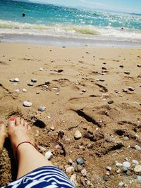 Low section of woman standing on beach