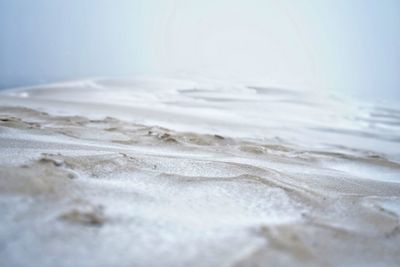 Surface level of sandy beach against sky