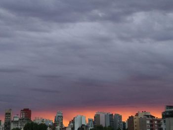 Buildings in city against sky during sunset