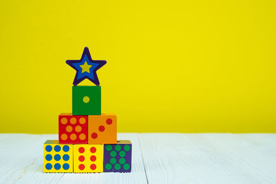 Close-up of toys on table against yellow background