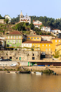 Buildings by river against sky