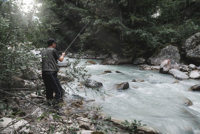 Full length of man fishing in forest