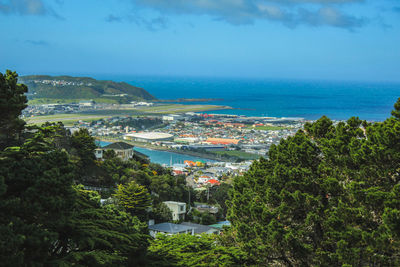 High angle view of city by sea against sky