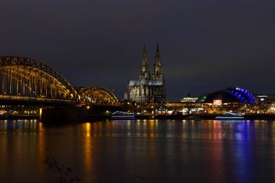 Illuminated bridge over river at night