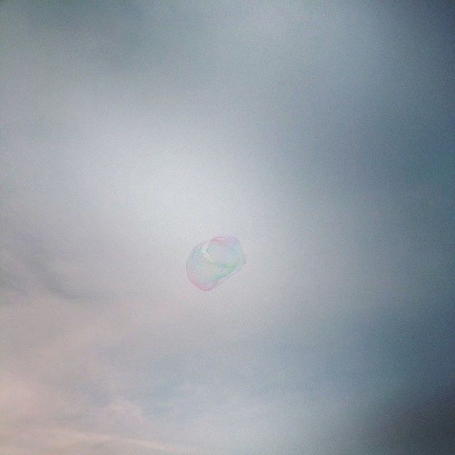 low angle view, mid-air, copy space, multi colored, blue, sky, beauty in nature, nature, no people, circle, outdoors, tranquility, day, balloon, bubble, flying, sphere, ball, scenics, sport