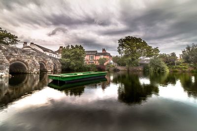 Bridge over river against cloudy sky