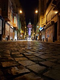 Empty road amidst buildings in city at night