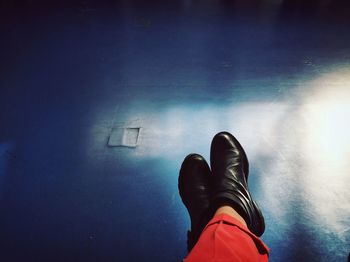 Low section view of man sitting with legs crossed at ankle