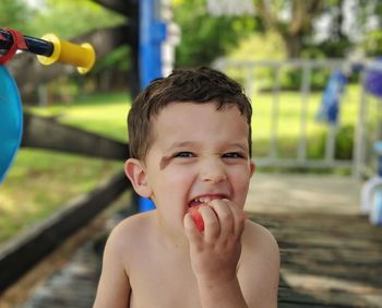 Portrait of cute boy eating food in park