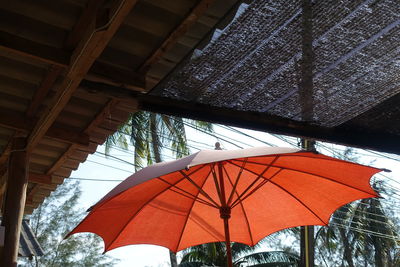 Low angle view of beach umbrella against covered roof