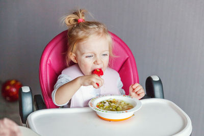 Cute girl eating food at home