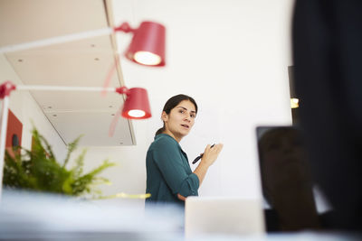 Low angle view of businesswoman discussing with female colleague in office