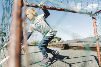 Girl playing hockey at yard against sky