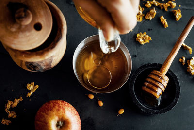 Natural honey is poured into a bowl, decorated with fruit and flowers