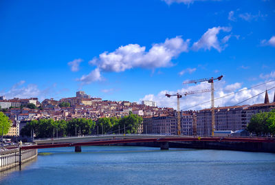 Bridge over river against buildings in city