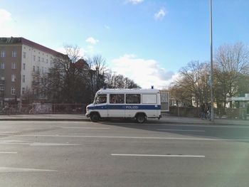 Car on road in city against sky