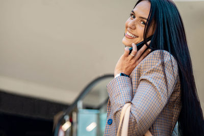 Portrait of smiling young woman using mobile phone