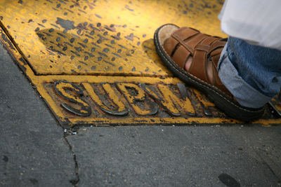 Low section of man wearing sandal at subway station