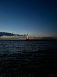 Lighthouse by sea against sky