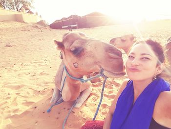 Young woman with camel on desert