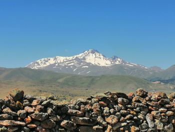 Scenic view of snowcapped mountains against clear blue sky