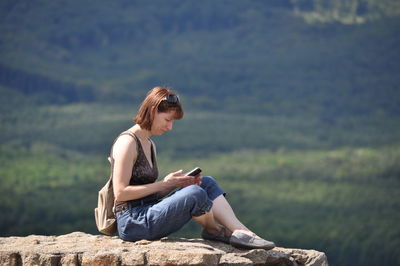 Portrait of woman sitting on mountain