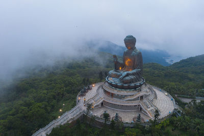 Statue amidst trees against sky