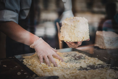 Midsection of man preparing food at commercial kitchen seen through glass window