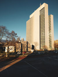 Road by buildings against sky in city