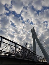 Low angle view of suspension bridge against sky