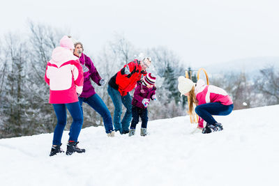 Rear view of women standing on field during winter