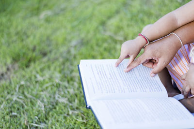 Midsection of woman reading book