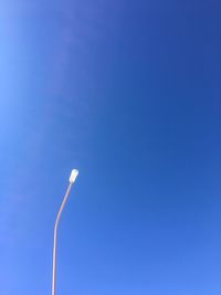 Low angle view of street light against blue sky