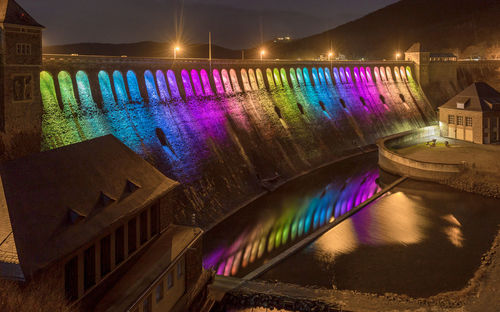 Illuminated bridge over canal in city at night