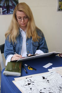 Young woman wearing eyeglasses on table