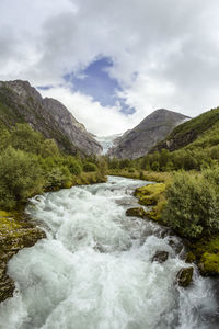 Scenic view of river amidst mountains against sky