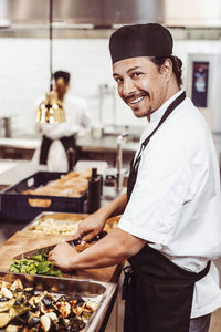 Side view of man preparing food in kitchen