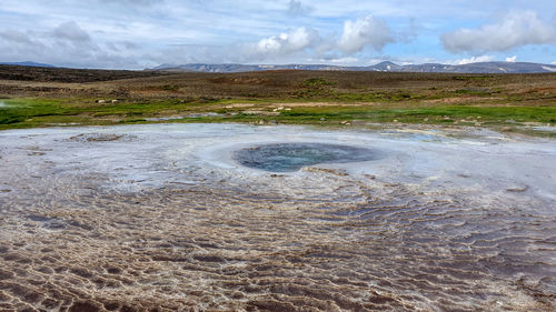 Scenic view of hot spring against sky