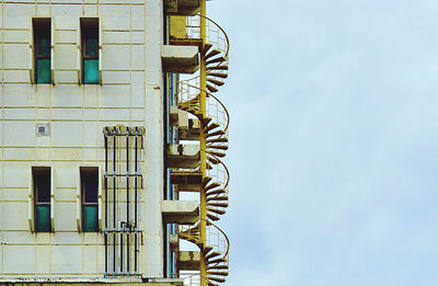 Low angle view of spiral staircase against building up in sky background