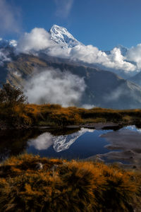 Scenic view of lake by snowcapped mountains against sky